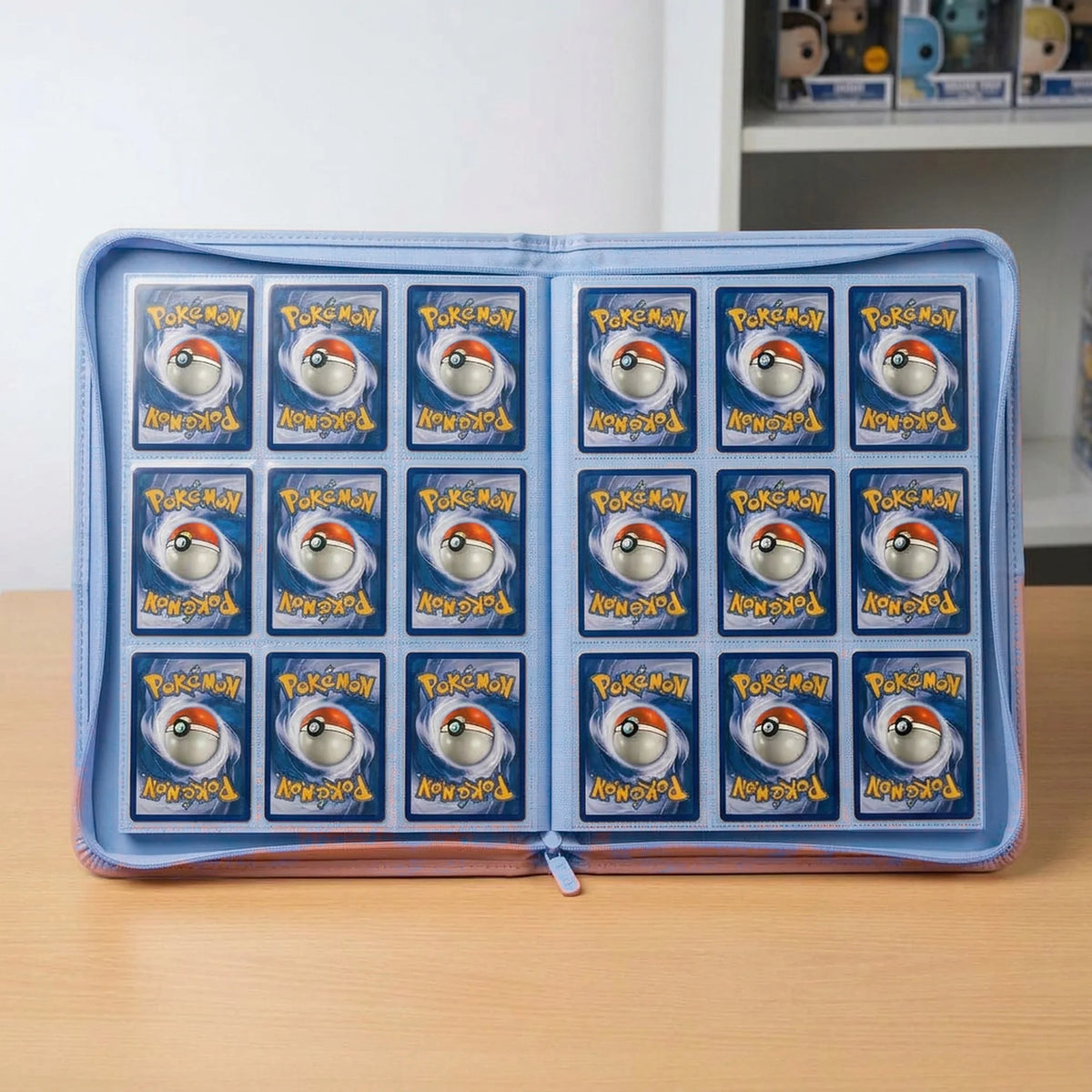 ellblauer 9-Pocket Binder stehend mit 18 Pokémon-Karten auf einer Doppelseite