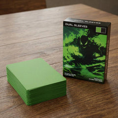 Realistisches Produktfoto der grünen Premium Dual Sleeves – Verpackung und Kartenhüllen in Nahaufnahme auf Holztisch, zeigt matte Oberfläche, Farbe und Qualität der Standard Size TCG Hüllen
